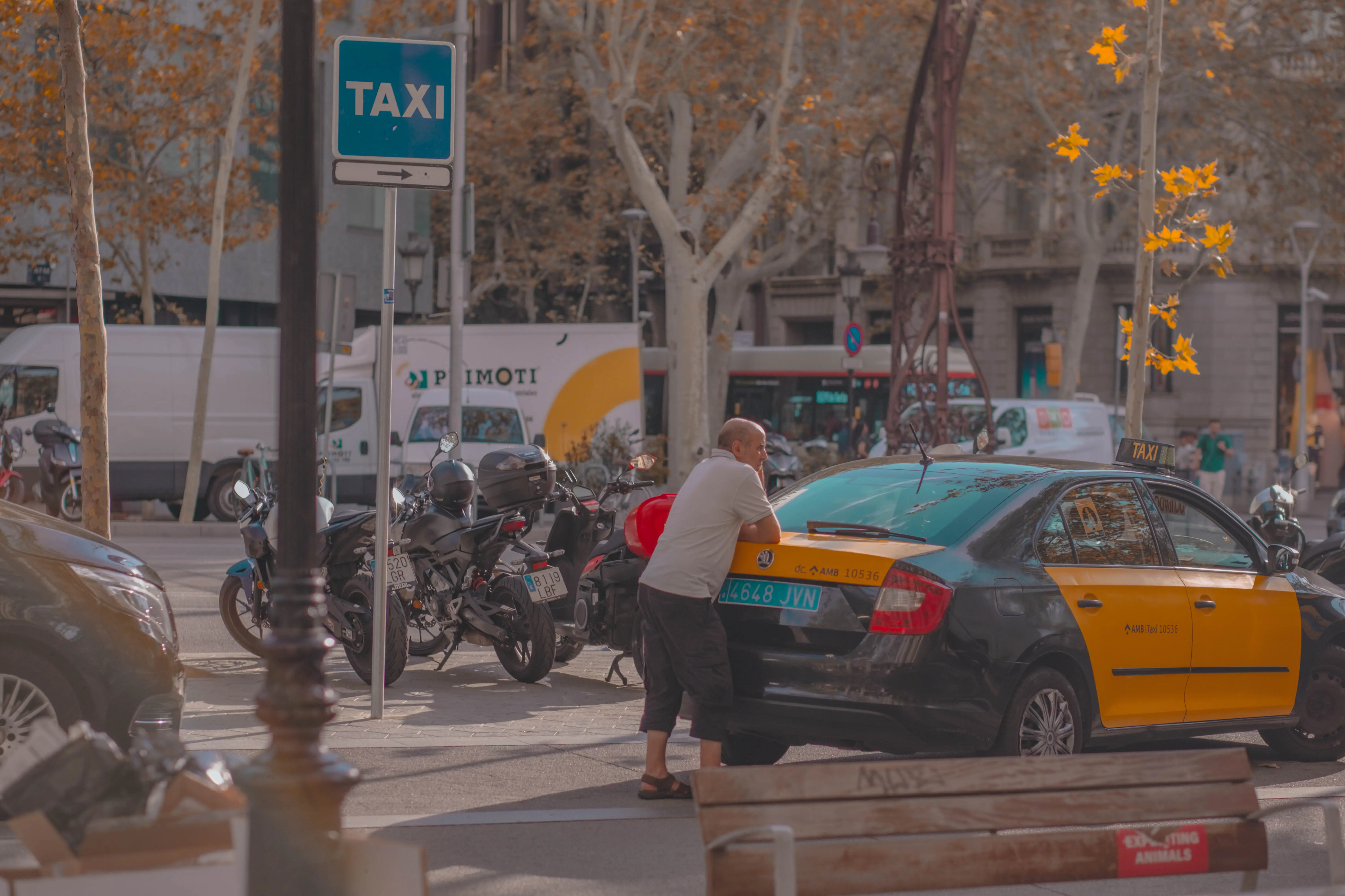 Homme appuyé contre un taxi de Barcelone stationné dans la rue